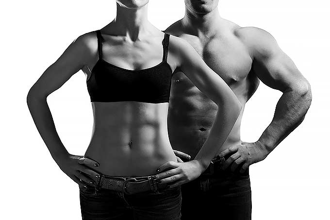 A man and a woman which are showing their muscular and fit bodies